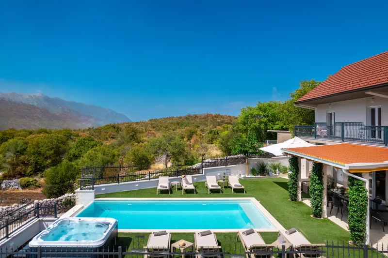 Pool, Jacuzzi and rows of loungers viewed from the upper floor