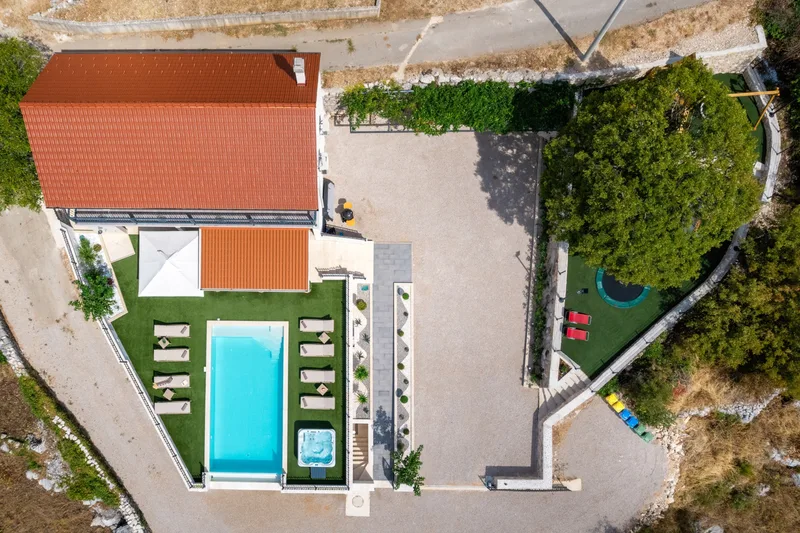 Top-down view of the villa, pool, parking area and playground