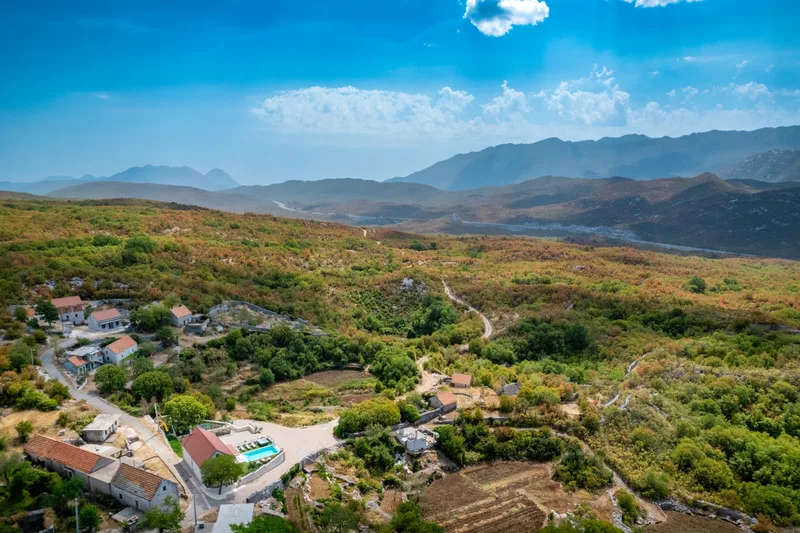 Villa grounds among village houses and wooded hills beneath Biokovo