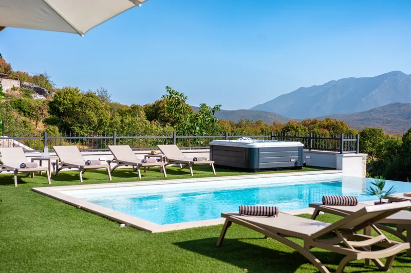 Pool and loungers with the Jacuzzi and mountains beyond