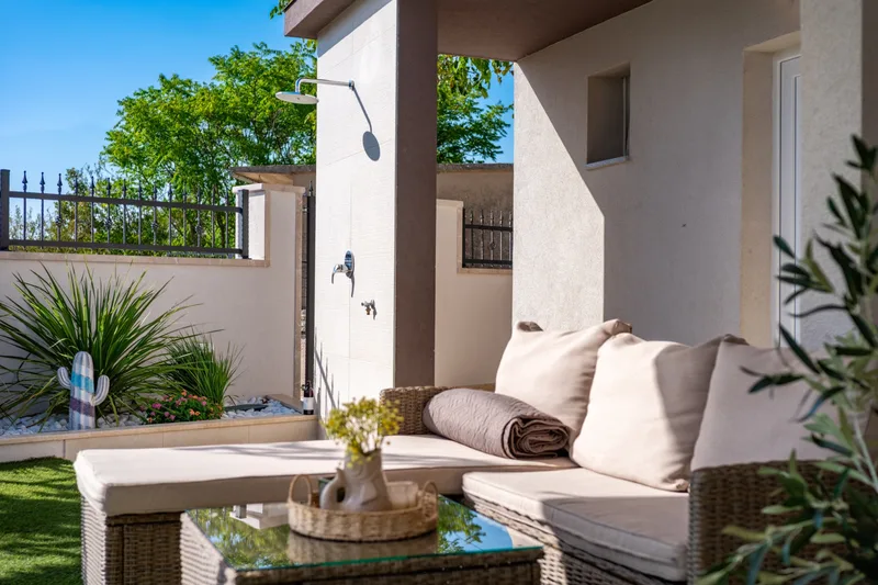 Sofa and low table in the covered lounge beside the garden