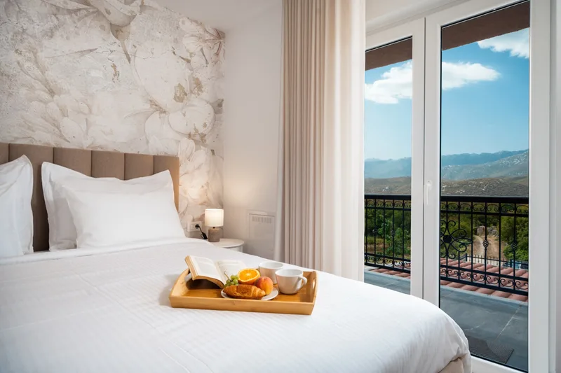 Double bedroom with a breakfast tray and glazed doors to the balcony