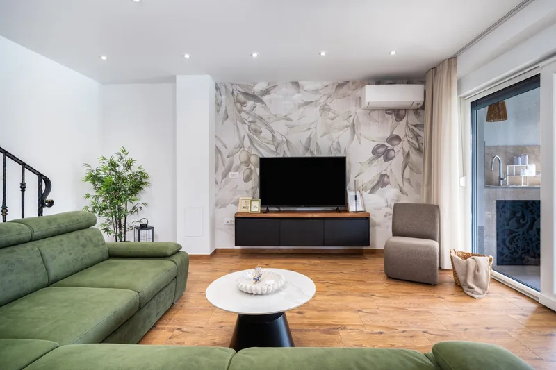 Green sofa, round coffee table and television in the living room