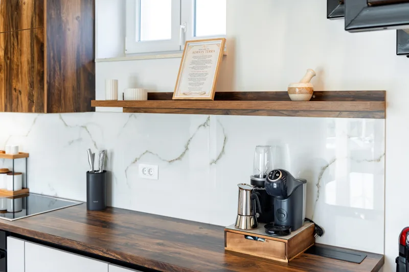 Kitchen counter with a coffee machine and open wooden shelves